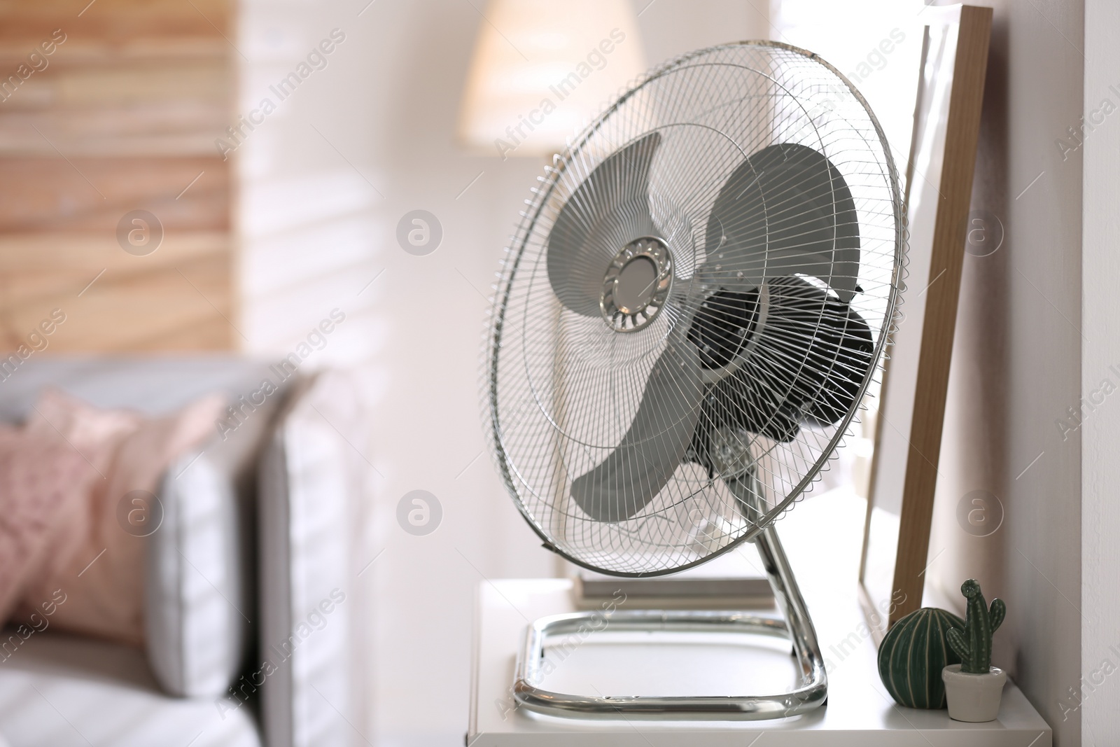 Photo of Modern electric fan on white table indoors. Space for text