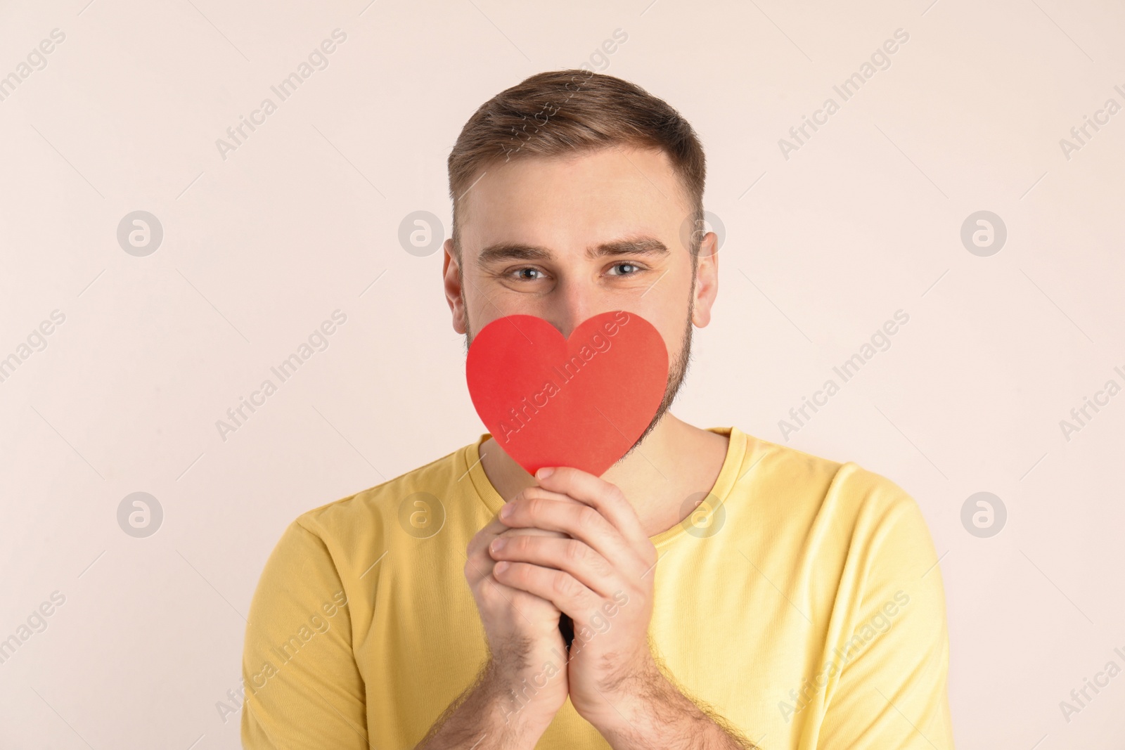 Photo of Young man with paper heart on white background