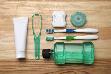 Photo of Flat lay composition with tongue cleaner and teeth care products on wooden table