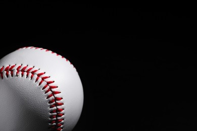 Photo of Baseball ball on black background, closeup. Space for text
