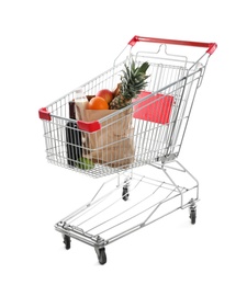 Photo of Shopping cart with groceries on white background