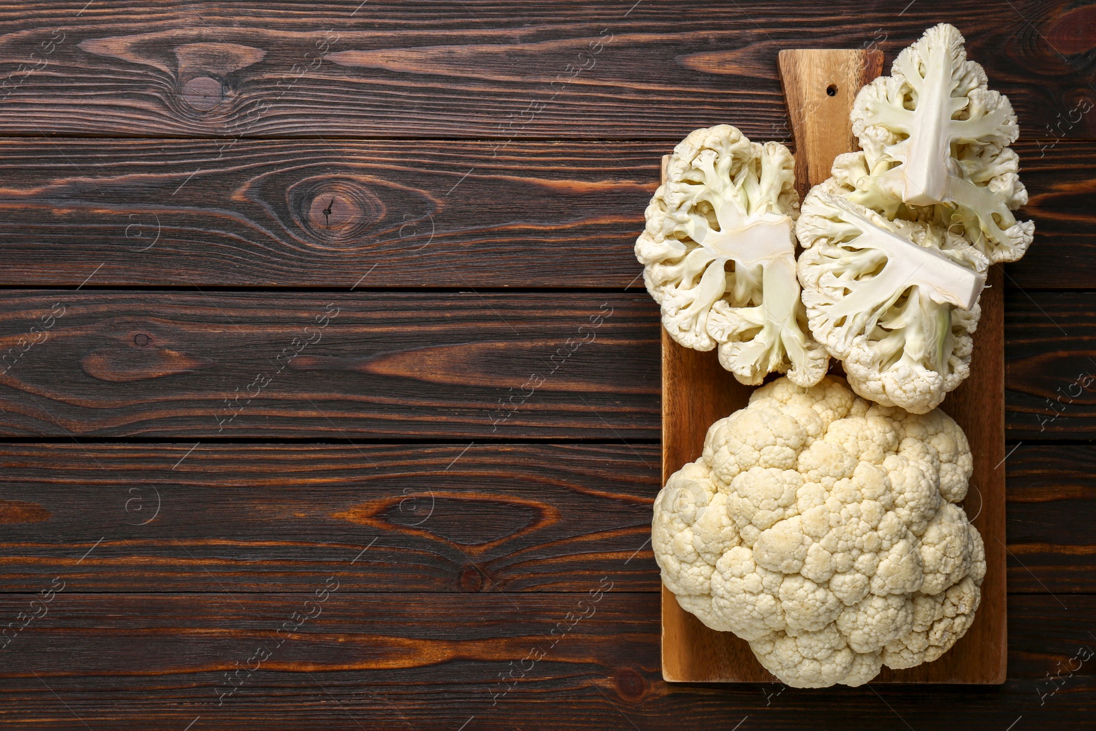 Photo of Fresh raw cauliflower on wooden table, top view. Space for text
