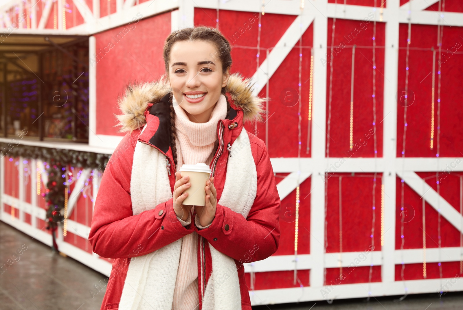 Photo of Young woman with hot drink at Christmas fair