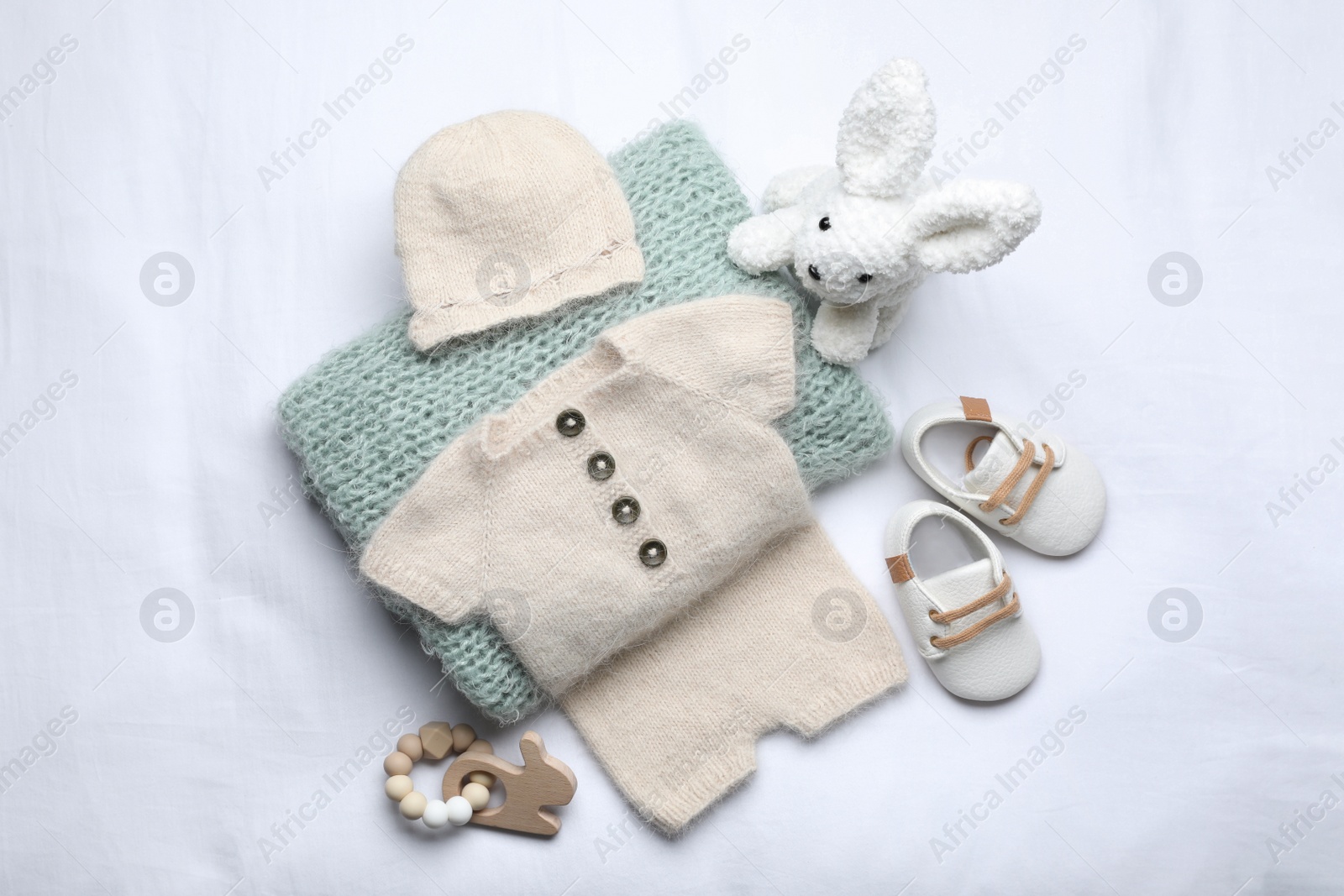 Photo of Flat lay composition with child's clothes and accessories on white fabric