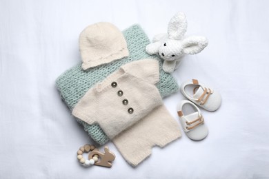 Flat lay composition with child's clothes and accessories on white fabric