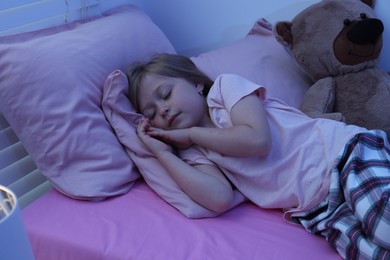 Photo of Little girl snoring while sleeping in bed at home