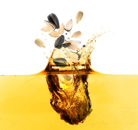 Sunflower seeds falling into cooking oil on white background