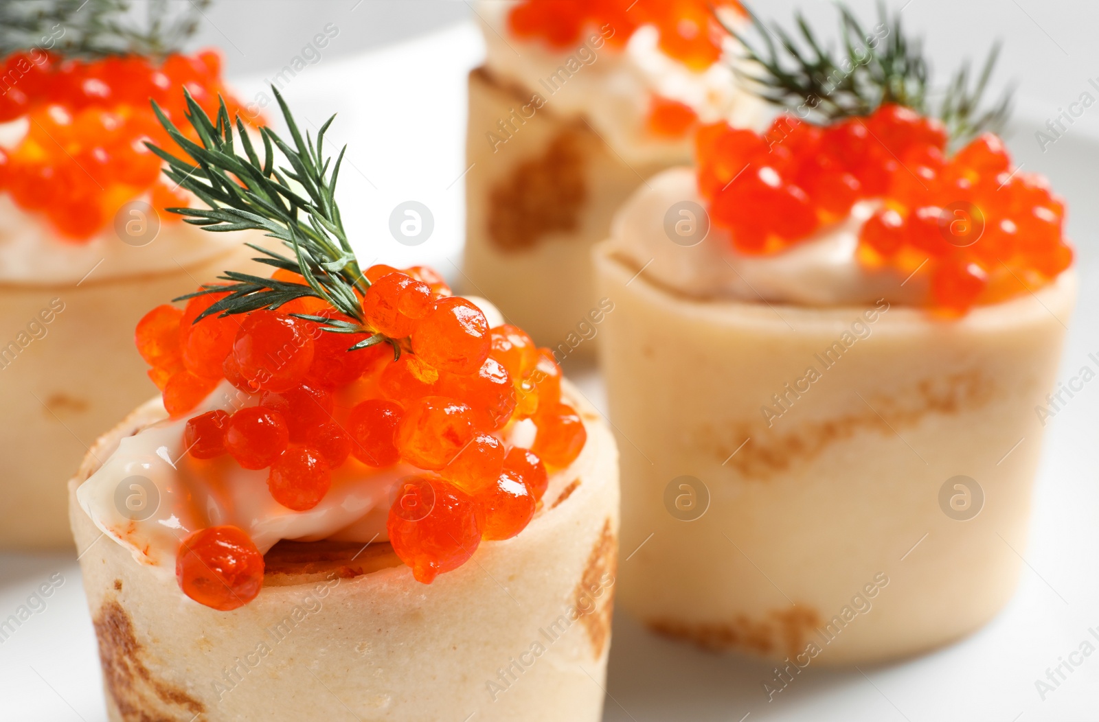 Photo of Delicious thin pancakes with red caviar, closeup