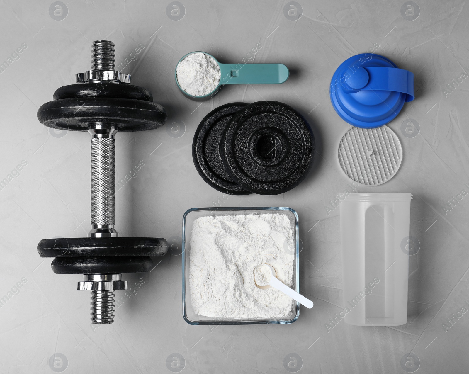 Photo of Flat lay composition with protein powder and dumbbell on grey background