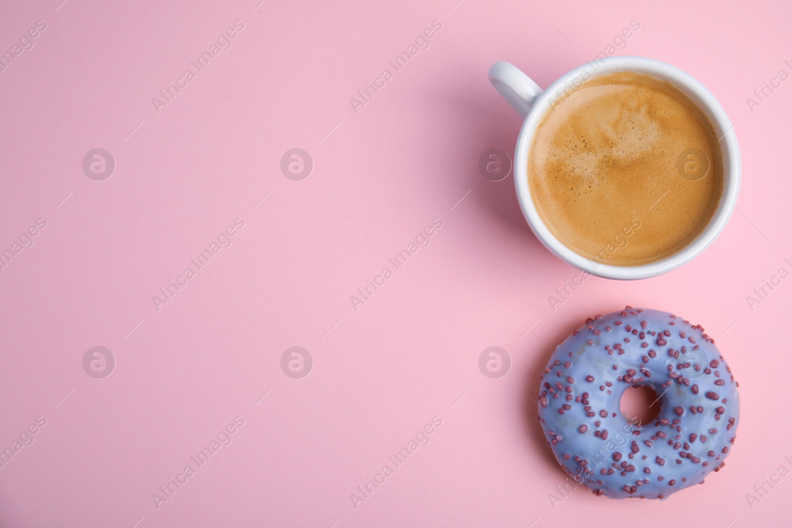 Photo of Delicious coffee and donut on light pink background, top view with space for text. Sweet pastries