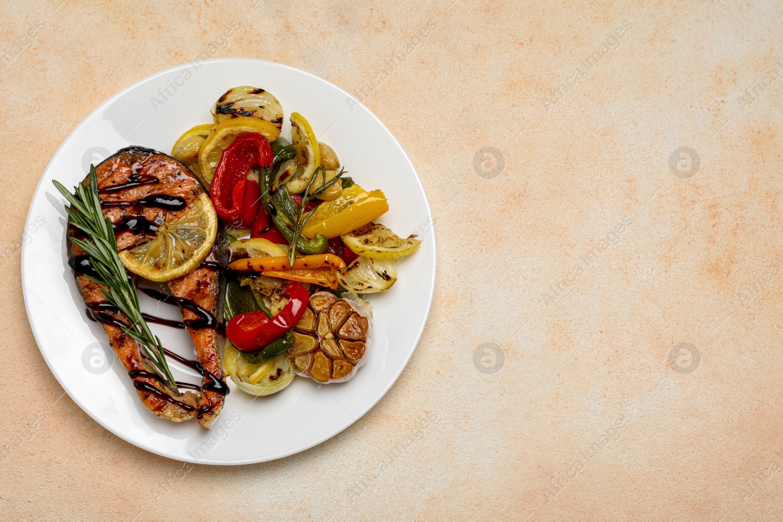 Photo of Tasty salmon steak with sauce, lemon and vegetables on light table, top view. Space for text