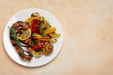 Photo of Tasty salmon steak with sauce, lemon and vegetables on light table, top view. Space for text