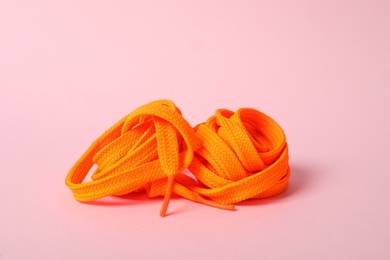 Photo of Orange shoe lace on light pink background