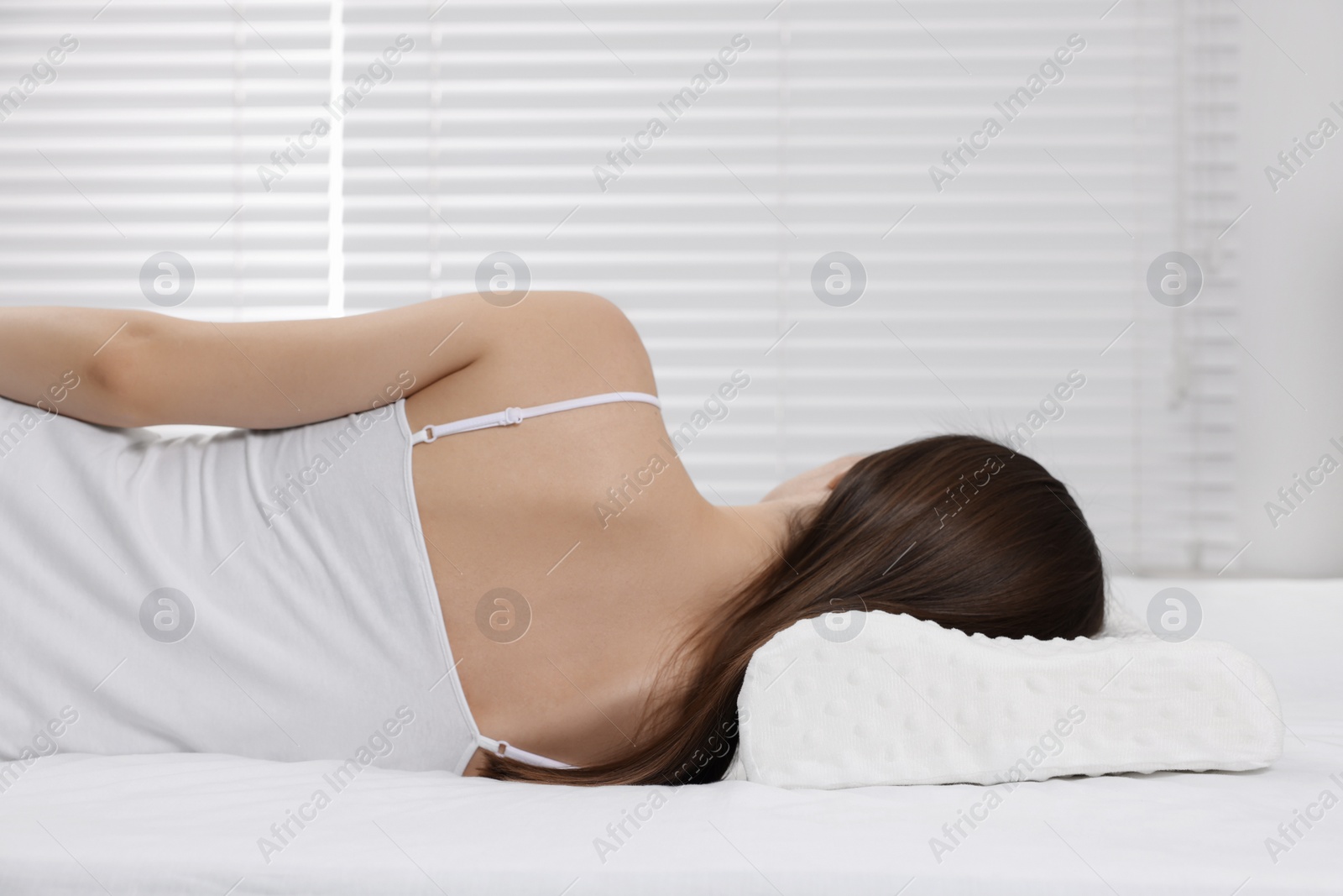 Photo of Woman sleeping on orthopedic pillow at home