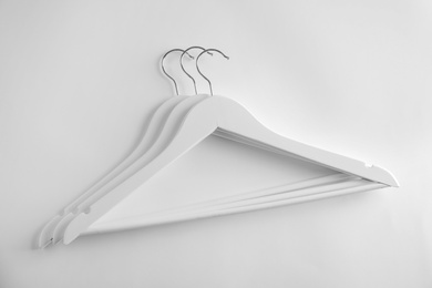 Photo of Empty clothes hangers on white background, top view