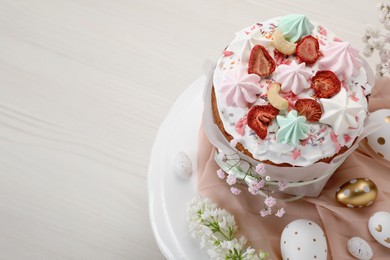 Traditional Easter cake with meringues and painted eggs on white wooden table, space for text
