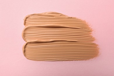 Photo of Sample of liquid skin foundation on pink background, top view