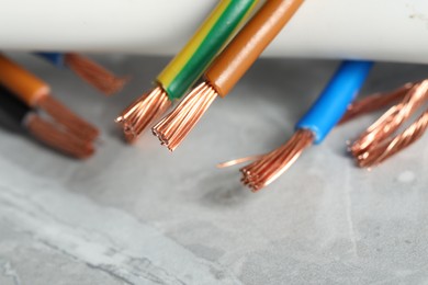 Photo of Colorful electrical wires on gray textured surface, closeup