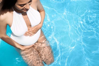 Photo of Beautiful pregnant woman in blue swimming pool