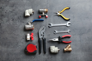 Photo of Flat lay composition with plumber's tools on grey background