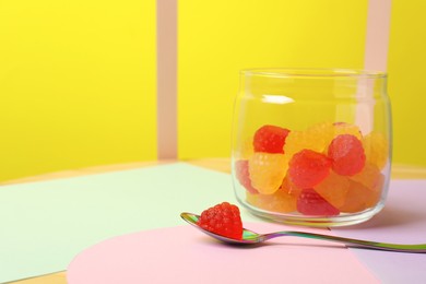 Photo of Delicious gummy raspberry candies on color background, space for text