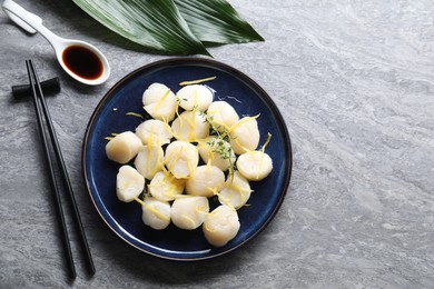 Photo of Raw scallops with thyme and lemon zest served on grey marble table, flat lay. Space for text
