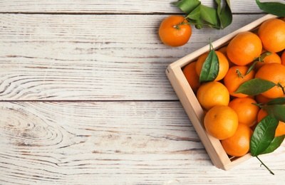 Crate with fresh ripe tangerines and space for text on wooden background, top view