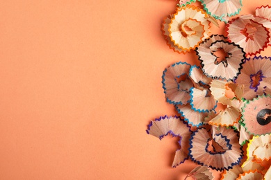 Photo of Pencil shavings on orange background, top view. Space for text