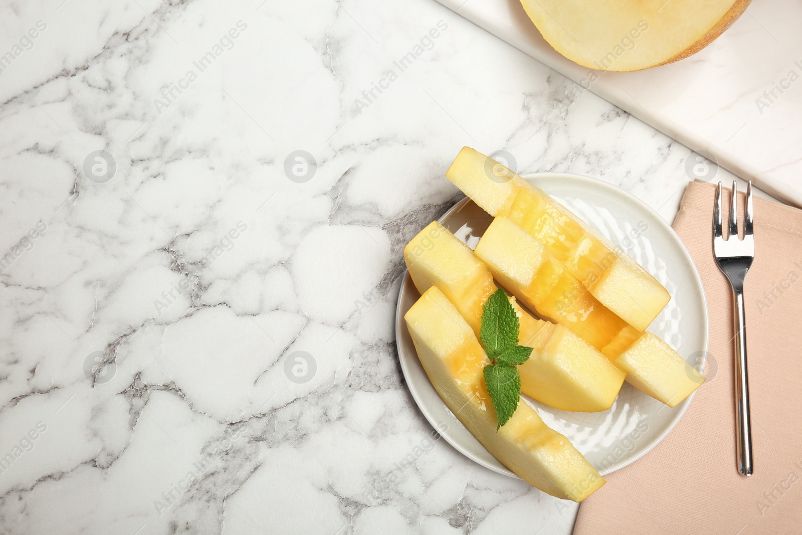 Photo of Flat lay composition with cut tasty melon on table. Space for text