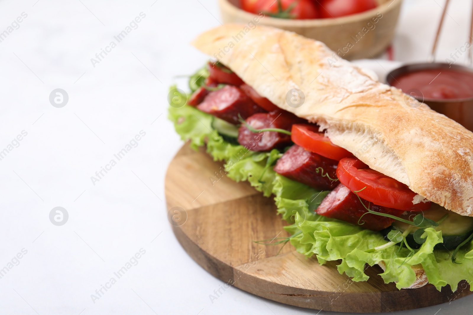 Photo of Delicious sandwich with sausages and vegetables on white table, closeup. Space for text