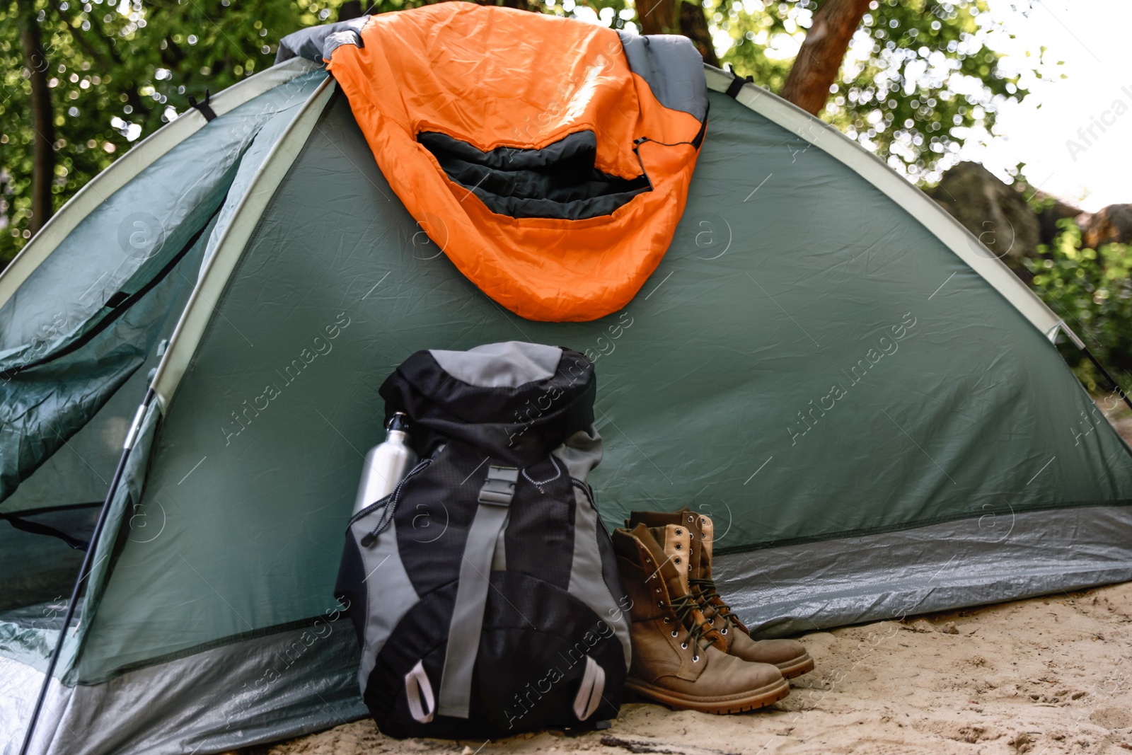 Photo of Camping tent with sleeping bag, boots and backpack on beach