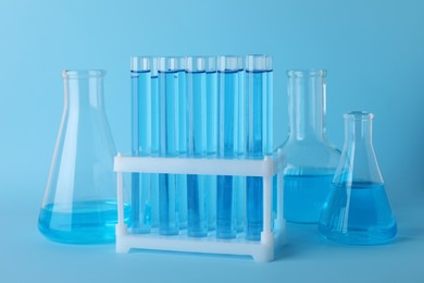 Photo of Laboratory glassware with light blue liquid on turquoise background