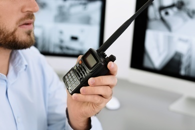 Male security guard with portable transmitter indoors, closeup