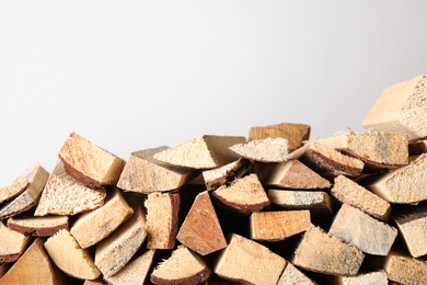 Cut firewood on light grey background. Heating in winter