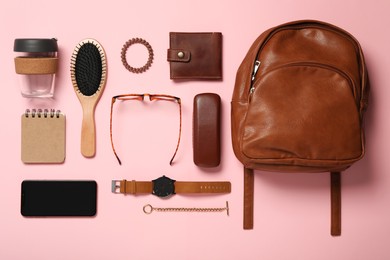 Photo of Stylish urban backpack and different items on pink background, flat lay