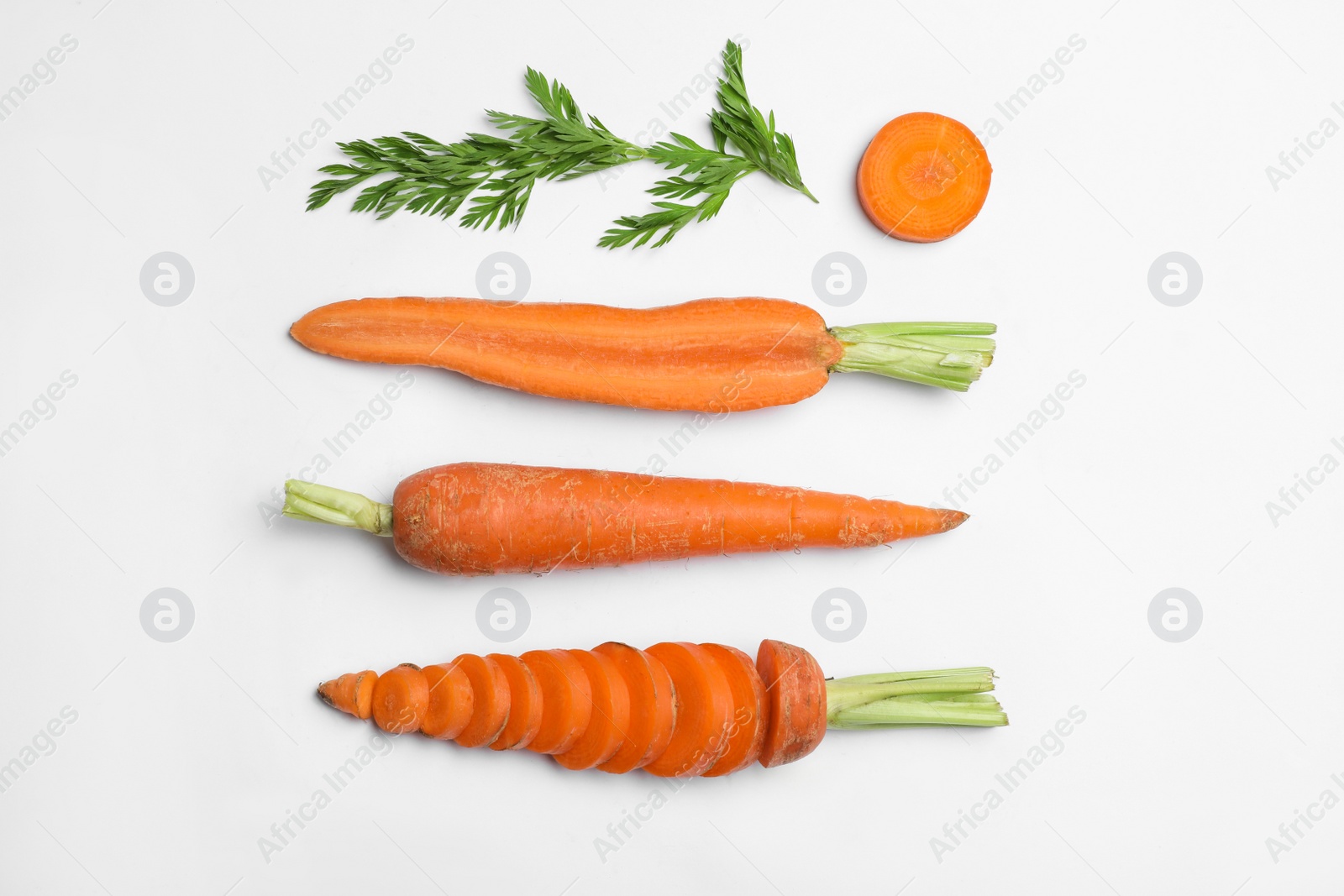 Photo of Tasty ripe carrots and leaves isolated on white, top view