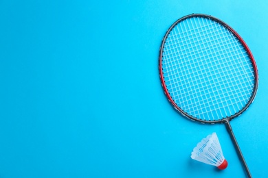 Photo of Badminton racket and shuttlecock on light blue background, flat lay. Space for text