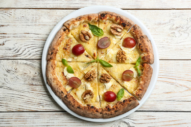 Photo of Delicious cheese pizza with walnuts and grapes on white wooden table, top view