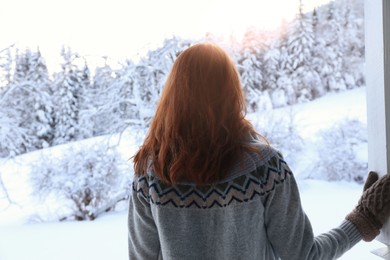 Photo of Woman on snowy day outdoors, back view. Winter vacation