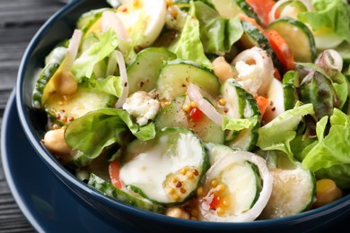 Photo of Bowl of delicious cucumber salad on table, closeup