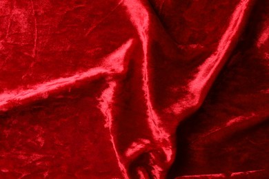 Texture of crumpled red velvet fabric as background, top view