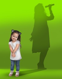 Dream about future occupation. Smiling girl and silhouette of singer on green background