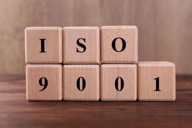 Cubes with abbreviation ISO and number 9001 on wooden table