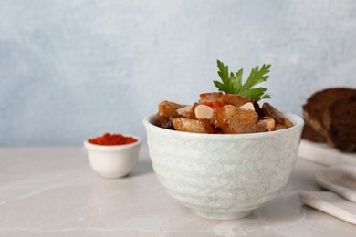Photo of Tasty fried cracklings on light table, space for text. Cooked pork lard