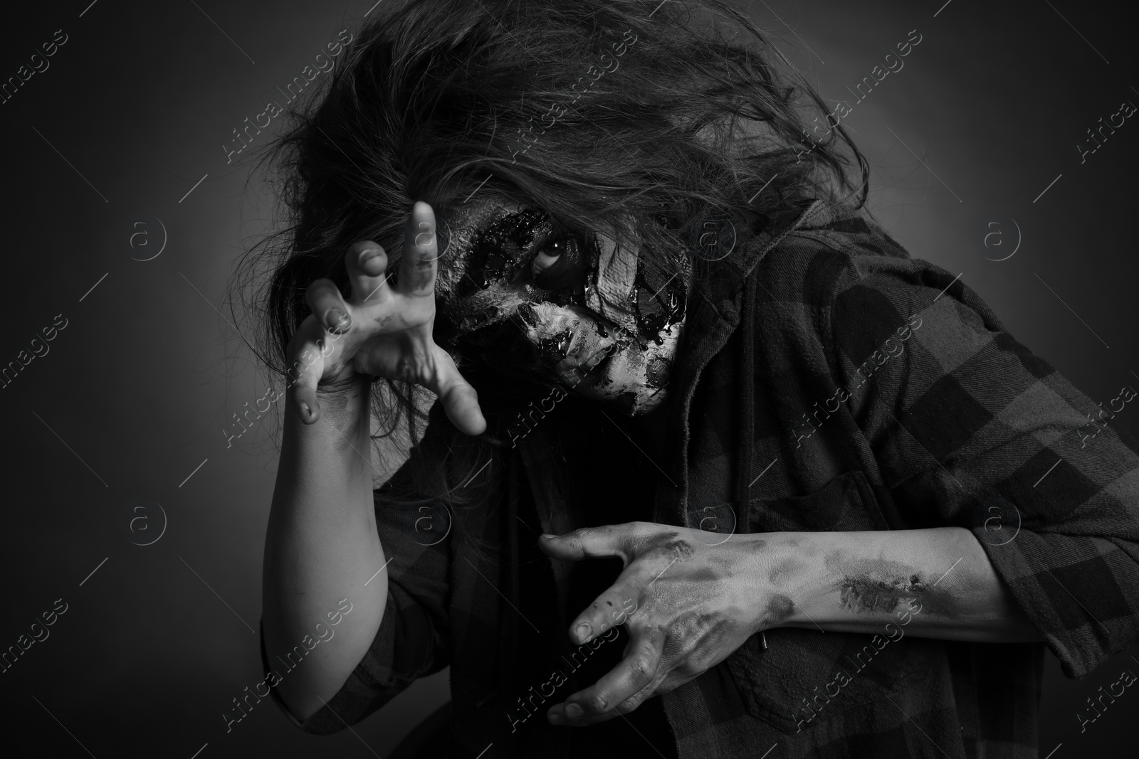 Photo of Scary zombie on dark background, black and white effect. Halloween monster