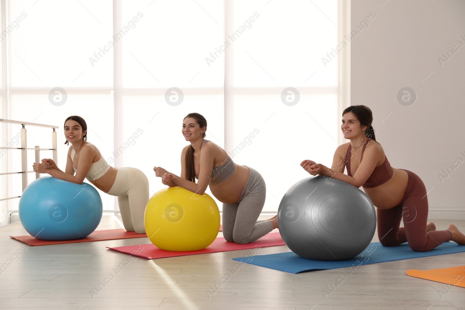 Photo of Group of pregnant women doing exercises in gym. Preparation for child birth