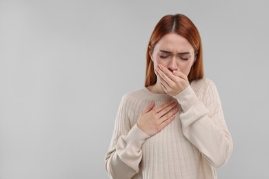 Photo of Woman coughing on light grey background, space for text. Cold symptoms