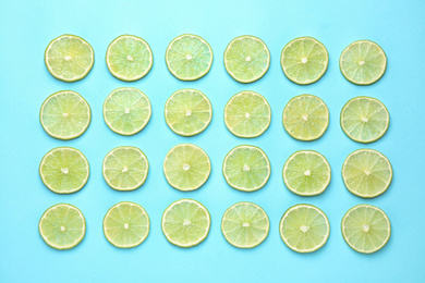 Photo of Fresh juicy lime slices on light blue background, flat lay