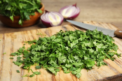 Wooden board with fresh green parsley on table, closeup