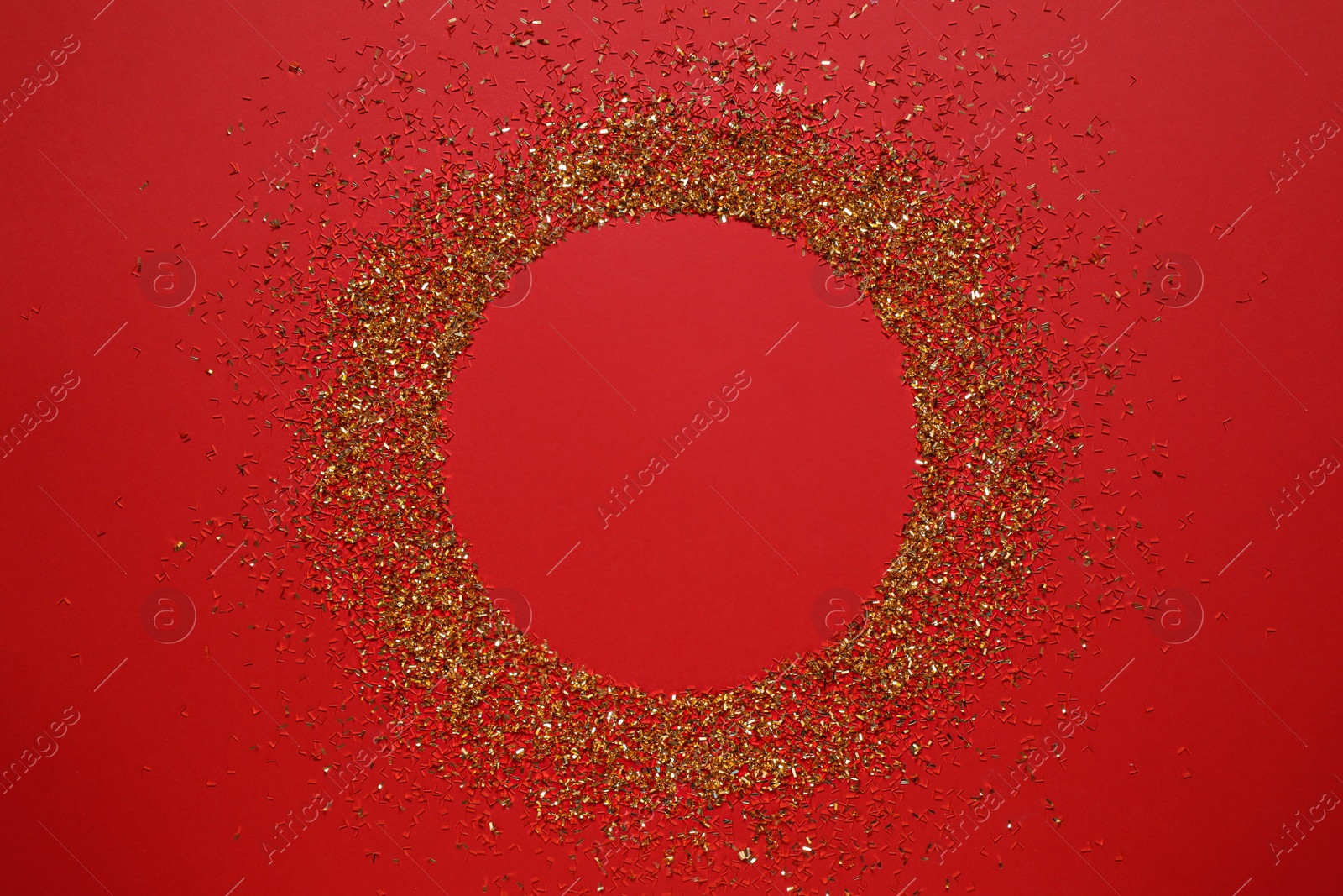 Photo of Frame of gold glitter on red background, top view. Space for text